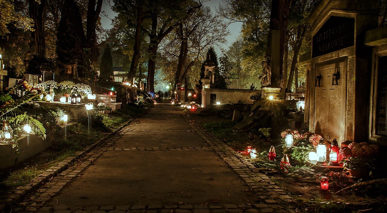 Cmentarz Rakowicki w Krakowie wieczorem w dniu Wszystkich Świętych, alejka ze zniczami