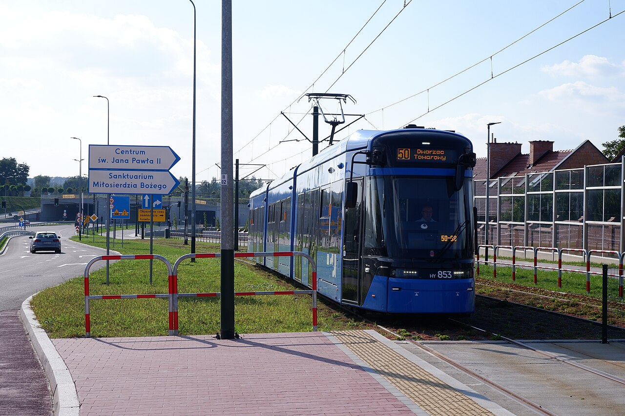 Niskopodłogowy tramwaj Stadler Lajkonik KMK na torowisku przy Trasie Łagiewnickiej w Krakowie